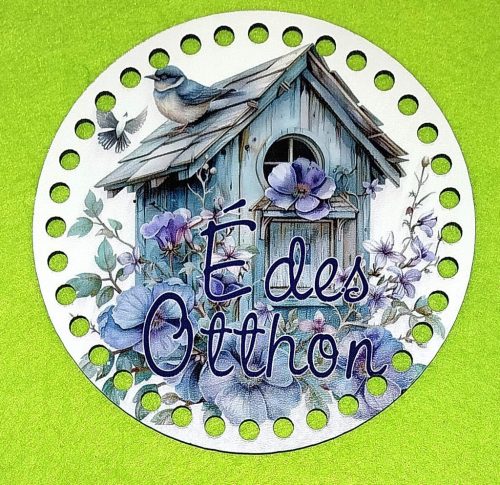 15cm Hranitoare pentru pasari tip casuta gri, cu baza din lemn imprimata crosetabil, flori mov si inscriptia Édes Otthon. Cu gaura de 7mm, 1buc/pachet, grosime 3mm. 